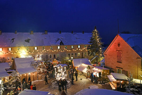 Bild vergrößern: Blick auf dem Weihnachtsmarkt der Festung Königstein in der Nacht mit Schnee